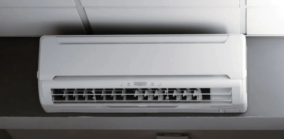 white air conditioner attached to a grey wall with a white ceiling
